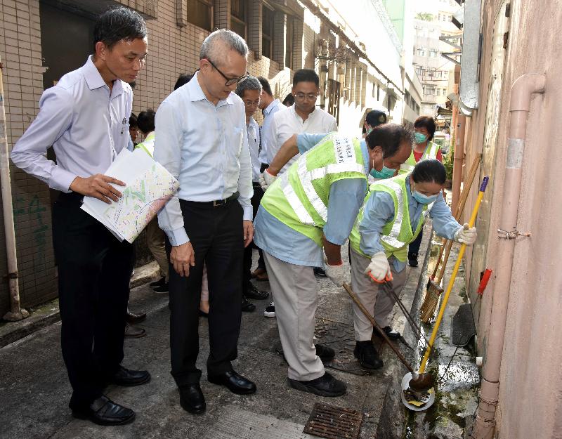 The District Environmental Hygiene Superintendent (Mong Kok) of the Food and Environmental Hygiene Department, Mr Edward Chan (first left), briefs the Under Secretary for Food and Health, Dr Chui Tak-yi (second left), on mosquito control measures today (August 11).