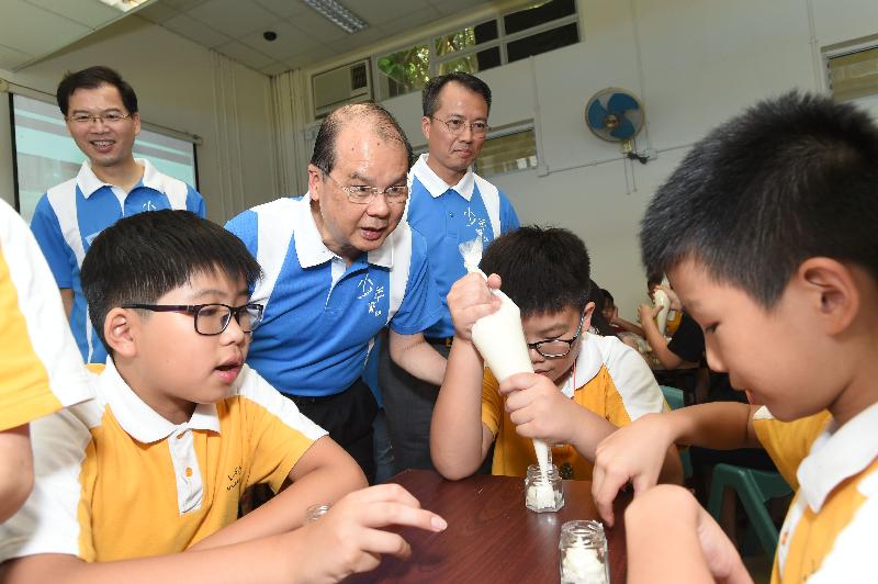 The Chief Secretary for Administration, Mr Matthew Cheung Kin-chung (centre), the Acting Secretary for Security, Mr Sonny Au (left), the Acting Commissioner of Police, Mr Lau Yip-shing (right) visit the candle-making workshop.
