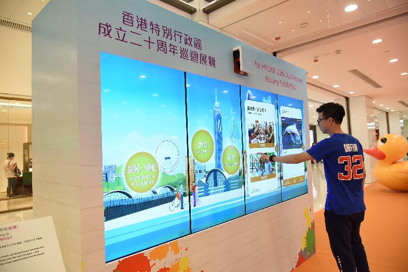 The "Hong Kong Special Administrative Region (HKSAR) 20th Anniversary Roving Exhibition" opens at the Ocean Terminal Main Concourse at Harbour City in Tsim Sha Tsui today (August 17). Photo shows a visitor learning about the developments and achievements of the HKSAR over the past 20 years through the LED touchscreen panel at the venue.