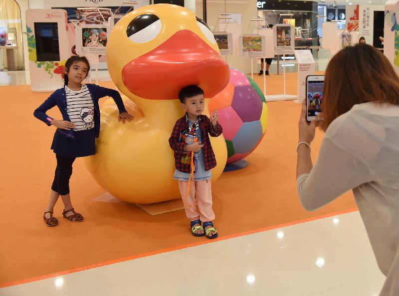 The "Hong Kong Special Administrative Region (HKSAR) 20th Anniversary Roving Exhibition" opens at the Ocean Terminal Main Concourse at Harbour City in Tsim Sha Tsui today (August 17). Photo shows a visitor taking photos of her children with the giant rubber duck and football. 