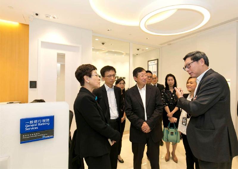 The Vice Chairman and Chief Executive Officer of China Construction Bank (Asia), Mr Jiang Xianzhou (third left), introduces the services, target customer groups and future development direction of one of its branches to the Chief Executive of the Hong Kong Monetary Authority, Mr Norman Chan (first right), in Tin Shui Wai today (August 17).