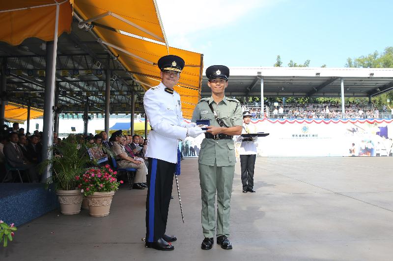 The Commissioner of Correctional Services, Mr Yau Chi-chiu (left), presents a Best Recruit Award, the Golden Whistle, to Assistant Officer II Mr Wang San-sum at the Passing-out cum Commissioner's Farewell Parade of the Correctional Services Department at its Staff Training Institute in Stanley today (August 18).