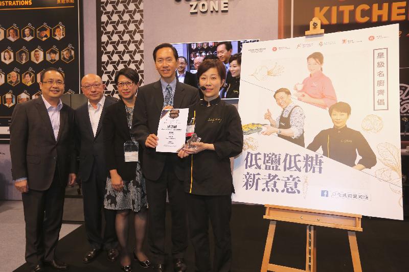 The Chairperson of the Committee on Reduction of Salt and Sugar in Food, Mr Bernard Chan (second right), presents a certificate to the renowned chef Sandy Keung (first right) as a token of appreciation at the "Star Chef Cooking Demonstration" session of the Food Expo today (August 18).
