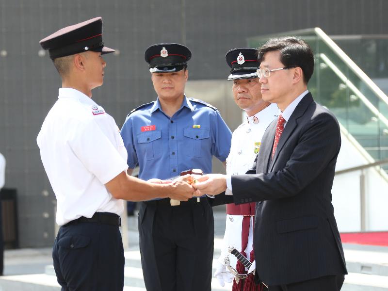 The Secretary for Security, Mr John Lee, reviewed the 179th Fire Services passing-out parade at the Fire and Ambulance Services Academy in Tseung Kwan O today (August 24). Picture shows Mr Lee (first right) presenting the Best Recruit award to a graduate.