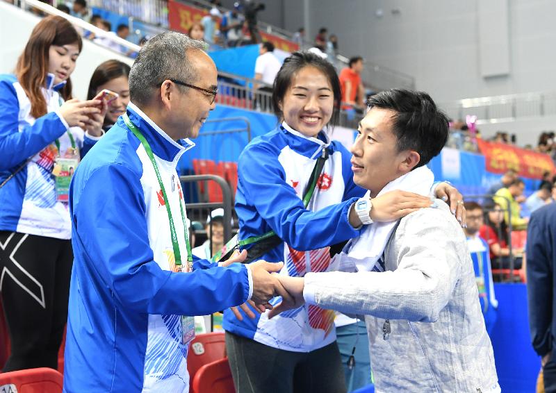 The Secretary for Home Affairs, Mr Lau Kong-wah (first left), watched a fencing competition at the 13th National Games in Tianjin today (August 28). Photo shows Mr Lau supporting athlete Lam Hin-chung (first right), a participant in the men's sabre individual event. Also present is Lam's sister, fencing athlete Lam Hin-wai (centre).