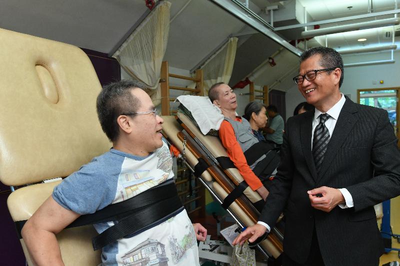 The Financial Secretary, Mr Paul Chan, visits SAHK Jockey Club New Page Inn as part of his visit to Sha Tin District today (August 28).  Photo shows Mr Chan (right) chatting with a patient to learn about his daily life.