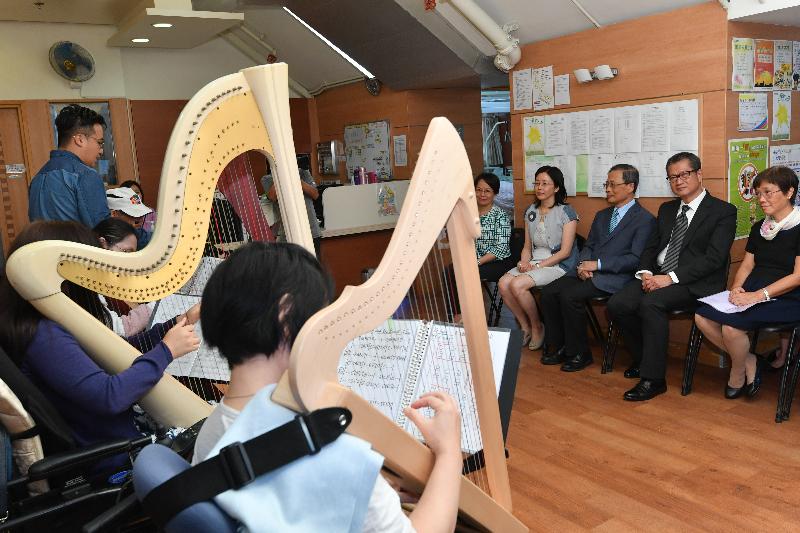 The Financial Secretary, Mr Paul Chan, visits SAHK Jockey Club New Page Inn as part of his visit to Sha Tin District today (August 28).  Photo shows Mr Chan (second right) enjoying the harp performance by the patients.