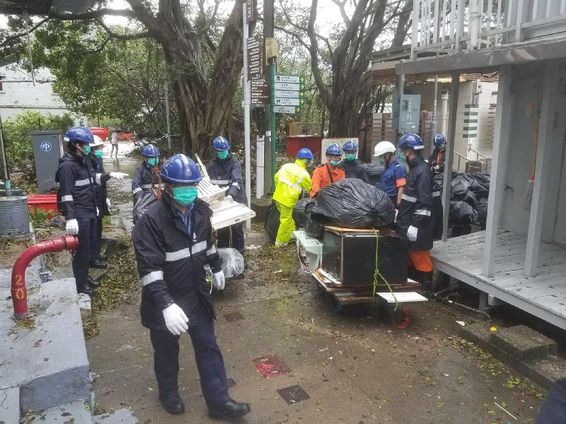 Civil Aid Service members assist the Food and Environmental Hygiene Department in clearing obstacles blocking thoroughfares in Tai O after Typhoon Pakhar.