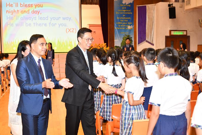 教育局局长杨润雄（左三）今日（九月一日）在基督教宣道会宣基小学开学礼上与学生握手问好。