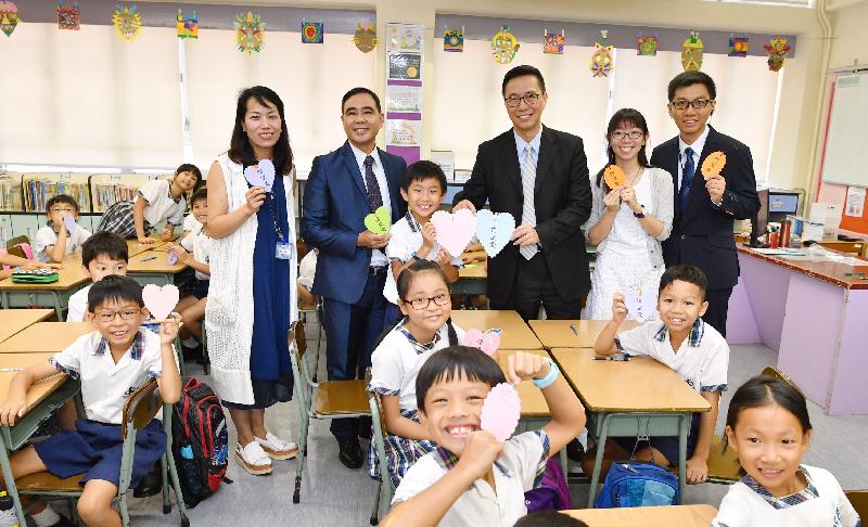 教育局局长杨润雄（后排右三）今日（九月一日）探访基督教宣道会宣基小学。图示杨润雄与老师及学生展示自制的书签。
