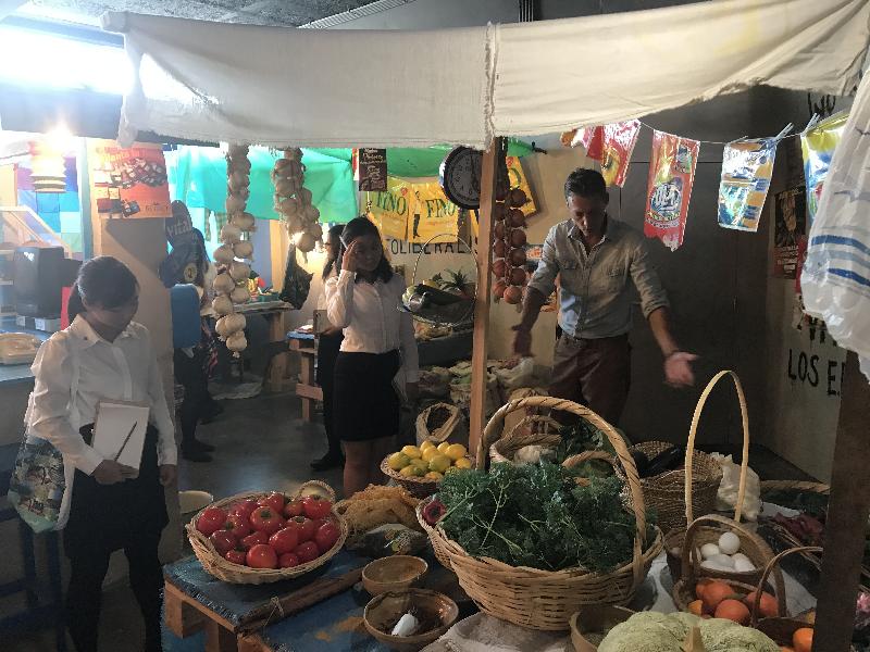 During a workshop on the impact of climate change on food production, a representative of Oxfam Solidarity in Brussels, Belgium, on August 29 shows young Hong Kong participants of the "Walk the Hong Kong Spirit" programme around a recreation of a typical grocery store in Bolivia.