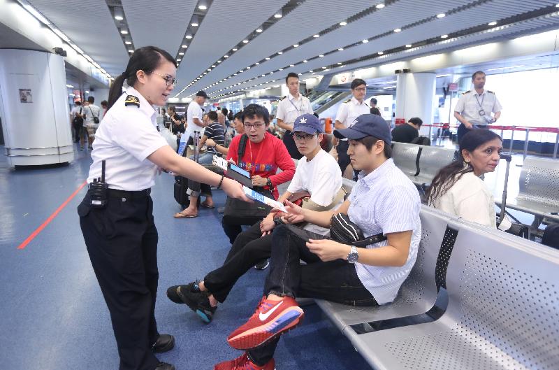 Marine inspectors of the Marine Department distribute promotional leaflets to passengers at the waiting lounge of the Hong Kong-Macau Ferry Terminal in Sheung Wan today (September 5) to promote the message that passengers on high-speed craft plying between Hong Kong and Macau should have their seat belts fastened. 