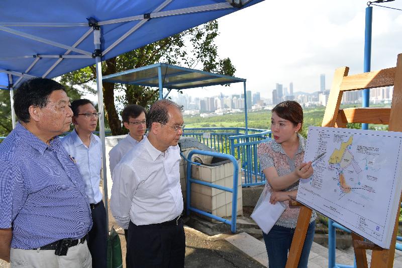 The Chief Secretary for Administration, Mr Matthew Cheung Kin-chung (second left), is briefed by the District Planning Officer (Fanling, Sheung Shui & Yuen Long East District Planning Office)of the Planning Department, Ms Maggie Chin (first right), on the development of the Lok Ma Chau Loop this afternoon (September 8). Looking on was the Chairman of the North District Council, Mr So Sai-chi (first left).