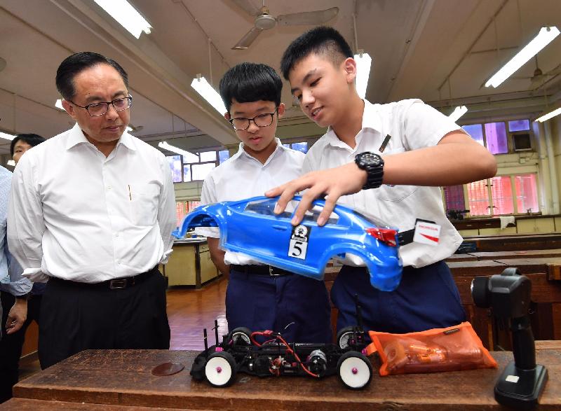 The Secretary for Innovation and Technology, Mr Nicholas W Yang (first left), looks on a model car made by students with their STEM (science, technology, engineering and mathematics) skills and 3D printing knowledge during his visit to the S.K.H. Tsang Shiu Tim Secondary School today (September 18).
