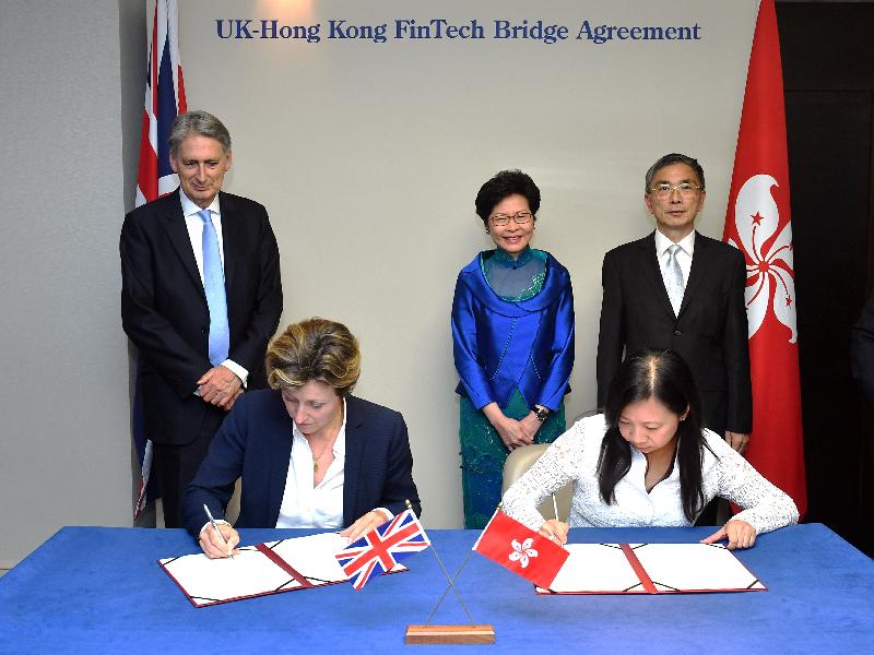 The Chief Executive, Mrs Carrie Lam, witnesses the signing of the Fintech Bridge agreement in London, the United Kingdom, yesterday (September 20, London time). Picture shows Mrs Lam (back row, centre) and the Chancellor of the Exchequer of the United Kingdom, Mr Philip Hammond (back row, left); the Secretary for Financial and the Treasury, Mr James Lau (back row, right); witnessing the signing of the agreement by the Special Representative for Hong Kong Economic and Trade Affairs to the European Union, Ms Shirley Lam (front row, right), and the Director General for Financial Services of the United Kingdom, Ms Katharine Braddick (front row, left).