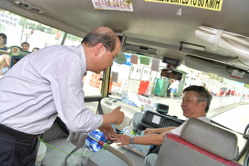 The Chief Secretary for Administration, Mr Matthew Cheung Kin-chung (left), visits a minibus stop at Shatin Pass Road and chats with a minibus driver this afternoon (September 27).
