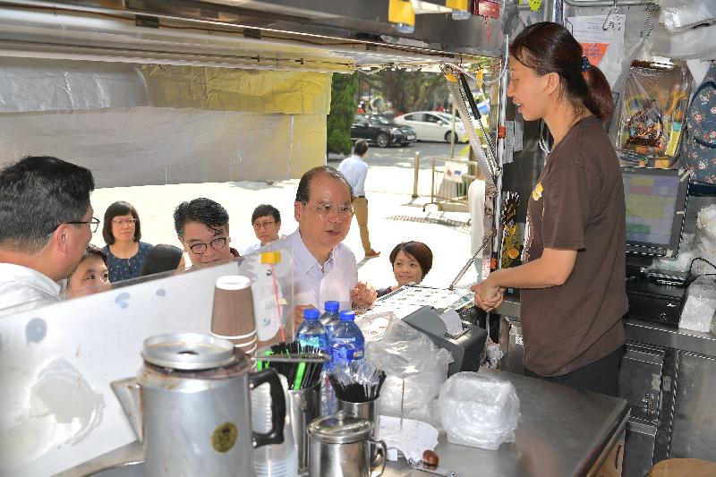 The Chief Secretary for Administration, Mr Matthew Cheung Kin-chung (third right), chats with staff of a food truck during his visit to Wong Tai Sin District this afternoon (September 27).