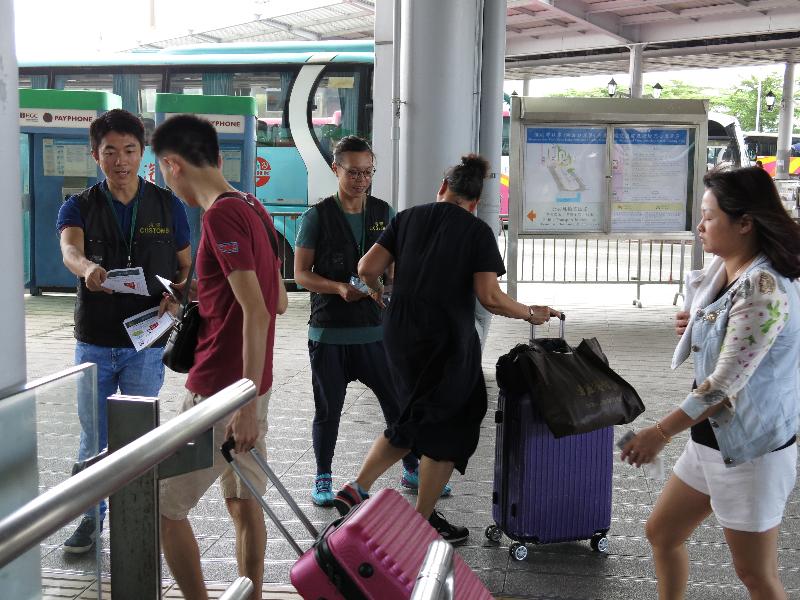 香港海关今日（九月二十九日）展开名为「神盾」的巡查行动，加强于「国庆黄金周」期间对旅客的消费保障。图示海关人员在过境巴士站提醒访港旅客精明消费。