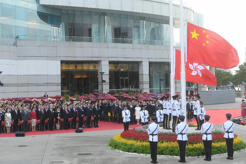 Guests watch solemnly as the National and Regional Flags are raised at the flag-raising ceremony in celebration of the 68th anniversary of the founding of the People's Republic of China at Golden Bauhinia Square in Wan Chai this morning (October 1).