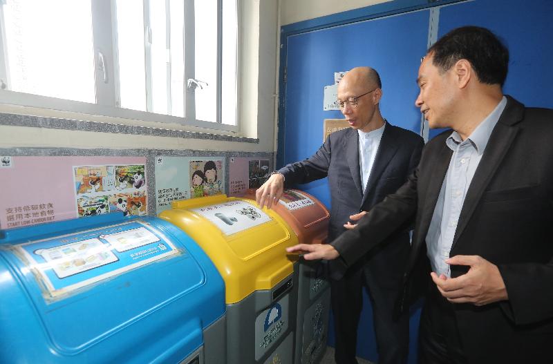 The Secretary for the Environment, Mr Wong Kam-sing (left), today (October 4) visits Lok Sin Tong Leung Kau Kui College. Picture shows Mr Wong being briefed by the school principal on the environmental protection work of the school.