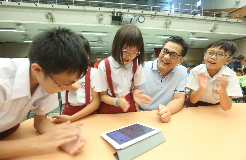 政府资讯科技总监杨德斌（右二）今日（十月七日）在「智能象棋同乐日──与大师过招」上，与学生一起跟人工智能系统对弈。