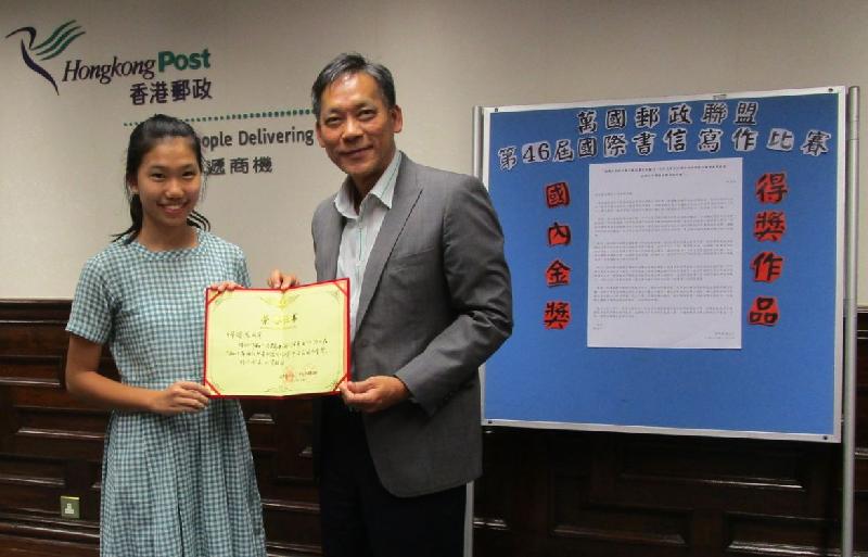香港郵政副署長魏永捷（右）今日（十月九日）向荃灣官立中學的傅頌恩同學頒發國家郵政局全國書信寫作比賽金獎。