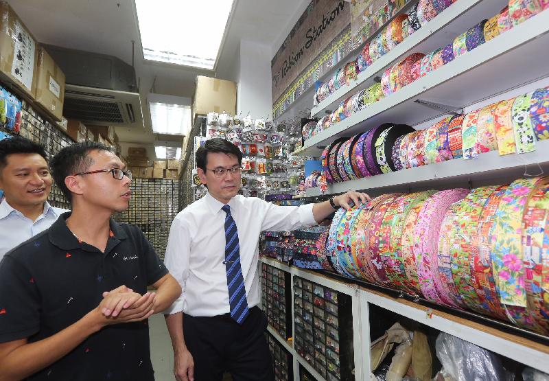 The Secretary for Commerce and Economic Development, Mr Edward Yau (first right), visited several wholesale shops of apparel and clothing accessories along Yu Chau Street and talked to shop owners to understand their business situation during his visit in Sham Shui Po District today (October 19).