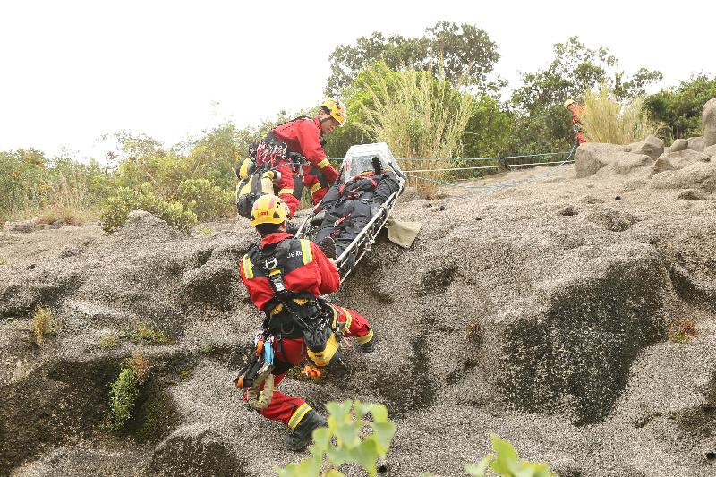 消防處人員在今日（十月十九日）舉行的跨部門山火暨攀山拯救行動演習中模擬拯救一名傷者。
