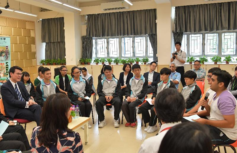 The Secretary for Commerce and Economic Development, Mr Edward Yau (first left), visited Chung Sing Benevolent Society Mrs Aw Boon Haw Secondary School today (October 24). Picture shows him chatting with students about issues such as tourism and economic development during his visit to Tuen Mun District.