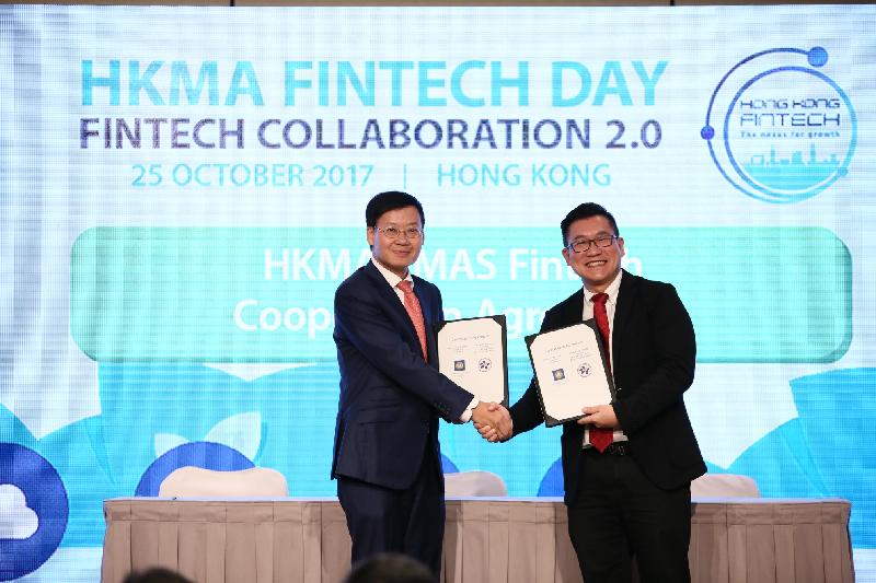 The Executive Director of the Hong Kong Monetary Authority (HKMA), Mr Li Shu-pui (left), and the Head of the Financial Centre Development Department of the Monetary Authority of Singapore, Mr Roy Teo (right), exchange a Co-operation Agreement, which was signed by the heads of the two organisations, at the HKMA Fintech Day today (October 25).