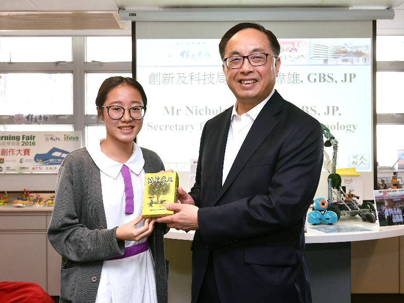 During his visit to Pak Kau College this afternoon (October 30), the Secretary for Innovation and Technology, Mr Nicholas W Yang (right), is presented with a set of the mathematics educational card system designed by student Chen Yu-xin (left) and her teammates. The team won first place in the Games in Development Competition of the ECGBL Educational Game Competition in early October.