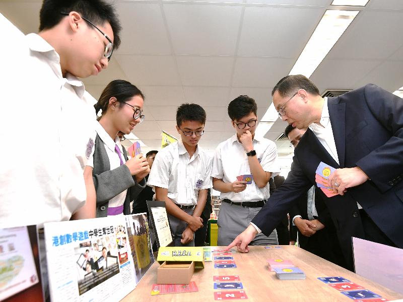 创新及科技局局长杨伟雄（右一）今日（十月三十日）下午访问伯裘书院时，试玩学生自行设计、刚于本月初赢得在奥地利举行的ECGBL教育游戏设计大赛研发组冠军的数学游戏卡牌。