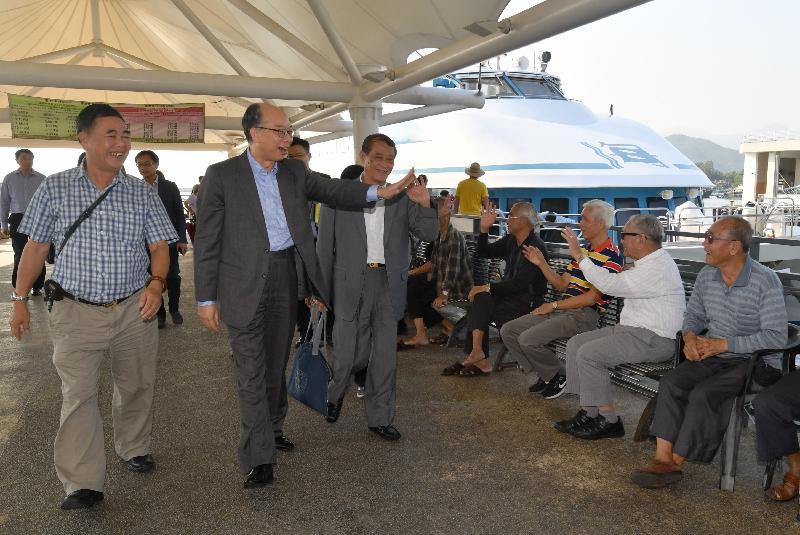 The Secretary for Transport and Housing, Mr Frank Chan Fan (second left), visited Cheung Chau today (November 10). Accompanied by the Chairman of the Islands District Council, Mr Chow Yuk-tong (third left), he greets the public upon arrival at Cheung Chau Pier.