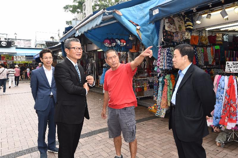 The Financial Secretary, Mr Paul Chan (second left), today (November 15) visits shops in Stanley Market. Joining him are the Chairman of the Southern District Council (SDC), Mr Chu Ching-hong (first left), and the Vice Chairman of the SDC, Mr Chan Fu-ming (first right).