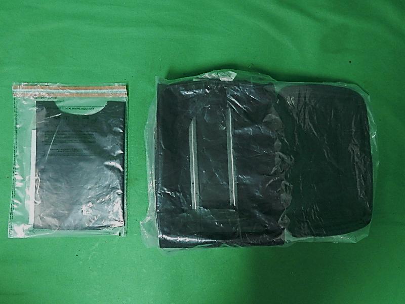 Hong Kong Customs yesterday (November 25) seized about 1.7 kilograms of suspected cocaine with an estimated market value of about $1.5 million from the false compartment of a luggage at Hong Kong International Airport. Photo shows the suspected cocaine seized (left) and the luggage (right).