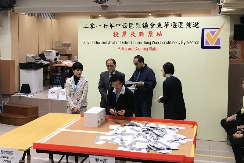 The Electoral Affairs Commission member, Mr Arthur Luk, SC (second left), inspects the counting station for the Central and Western District Council Tung Wah Constituency by-election at SKH St Matthew's Primary School last night (November 26).