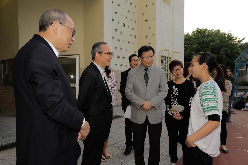 The Secretary for Home Affairs, Mr Lau Kong-wah (second left), chats with a student at China Holiness Church Living Spirit College this afternoon (November 30) during his visit to Tai Po District. Next to him is the Chairman of the Tai Po District Council, Mr Cheung Hok-ming (first left).