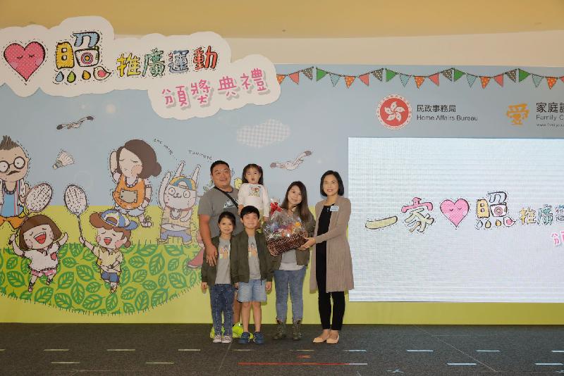The Permanent Secretary for Home Affairs, Mrs Betty Fung (first right), presents a prize to a winning family in the "Sports and Exercise" category at the prize presentation ceremony of the "Happy Moments of Family" Snapshot Competition jointly held by the Family Council and the Home Affairs Bureau today (December 3).