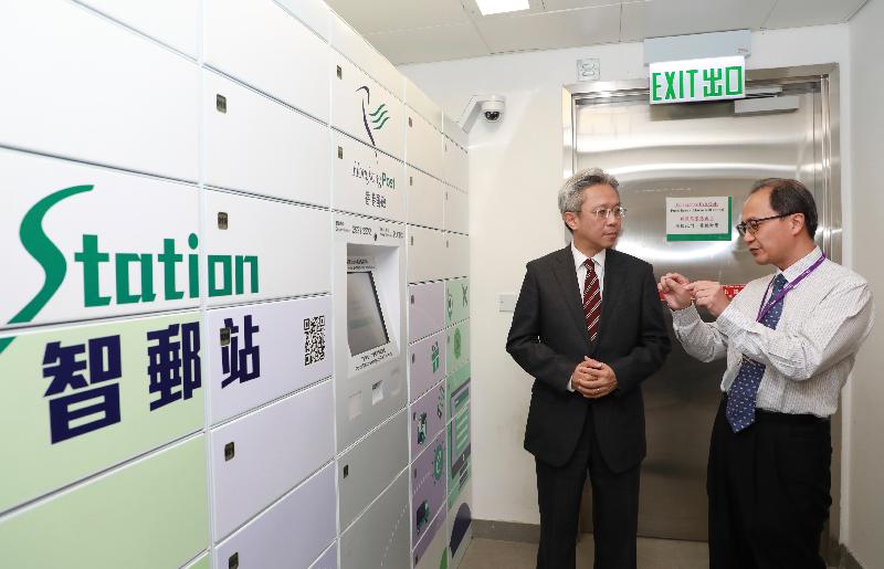 公务员事务局局长罗智光今日（十二月五日）到访香港邮政。图示罗智光（左）聆听部门同事讲解「智邮站」自助领件柜的运作。