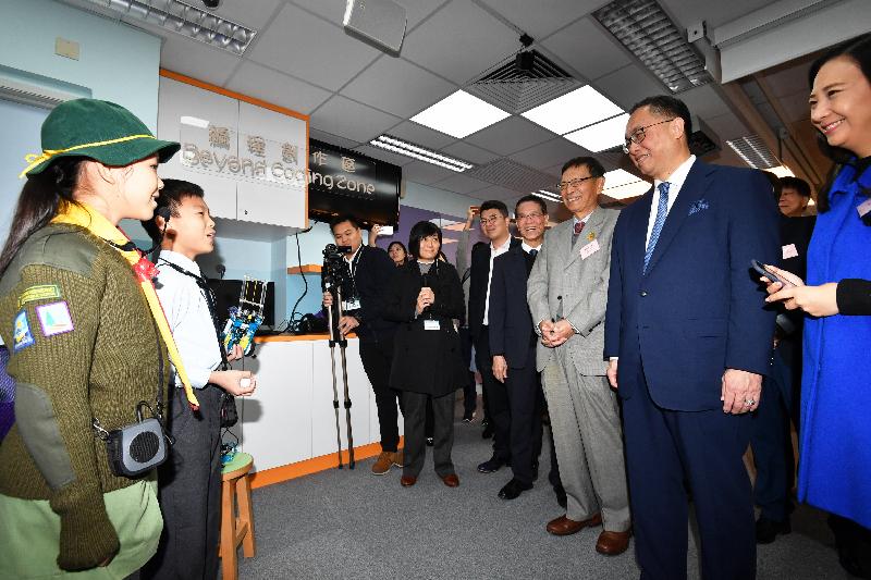 The Secretary for Innovation and Technology, Mr Nicholas W Yang (second right), listens to students talk about learning coding at the STEAM InnoArena during his visit to Fung Kai Innovative School today (December 11).