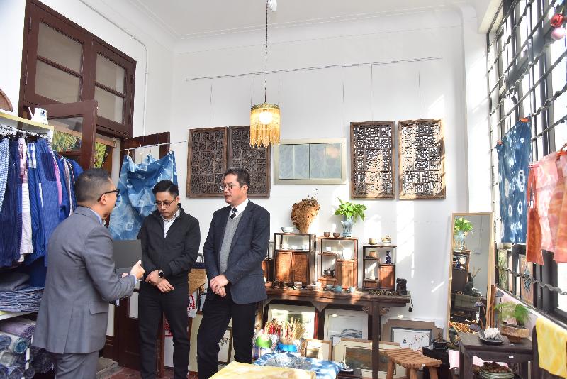 The Secretary for Development, Mr Michael Wong, visited Yau Tsim Mong District today (December 11) to see the preservation and revitalisation project at Prince Edward Road West and Yuen Ngai Street. Photo shows Mr Wong (first right) and the Chairman of the Yau Tsim Mong District Council, Mr Chris Ip (second right), visiting an art gallery which has preserved the original floor tiles and doors of a shophouse. 