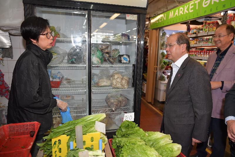 The Chief Secretary for Administration, Mr Matthew Cheung Kin-chung, visited Sai Kung District today (December 11). Photo shows Mr Cheung (second right), accompanied by the Chairman of the Sai Kung District Council, Mr George Ng (first right), discussing with a stall operator the business environment while touring Sai Kung Market.