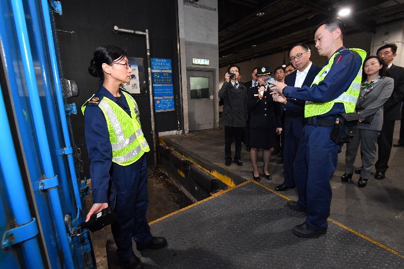 The Secretary for Innovation and Technology, Mr Nicholas W Yang (fourth right), receives a briefing from Customs officers on the implementation of the Single E-lock Scheme at the Asia Airfreight Terminal during his visit to Islands District today (December 14).