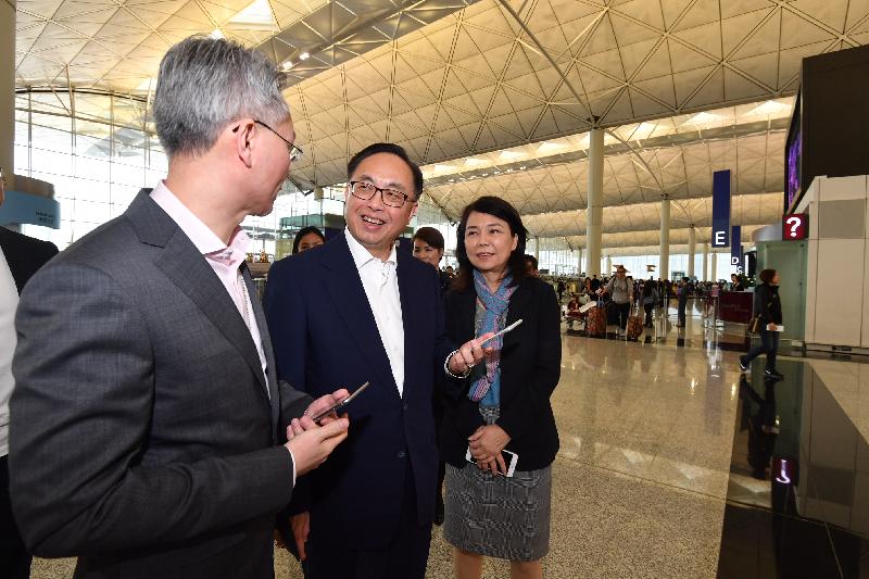 创新及科技局局长杨伟雄（中）今日（十二月十四日）在香港国际机场试用「我的航班」应用程式的扩增实境路线搜寻。旁为香港机场管理局机场运行副总监张李佳蕙（右）。