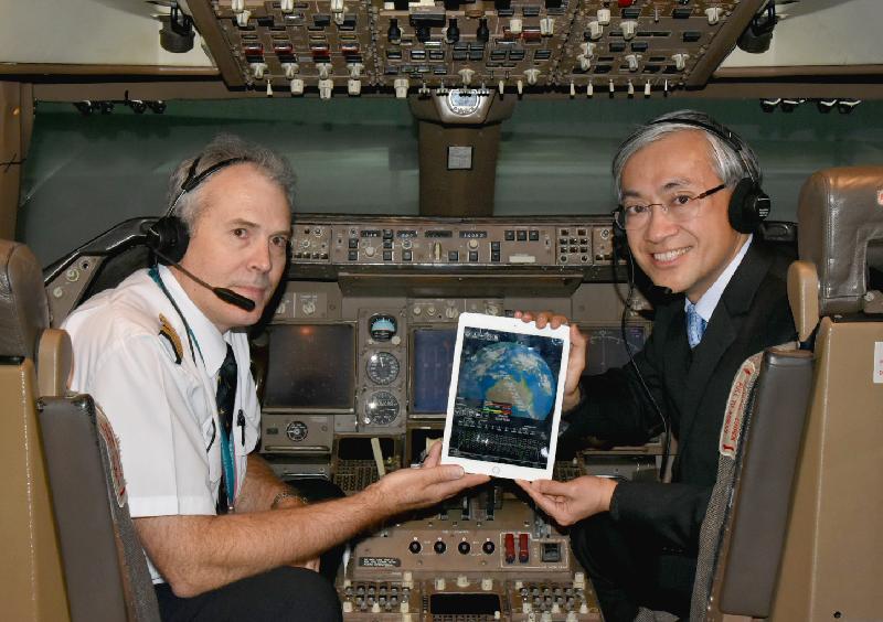The Hong Kong Observatory announced today (December 14) the launch of electronic flight bag mobile application"MyFlightWx". Photo shows the General Manager Operations of Cathay Pacific Airways, Mr Mark Hoey (left), and the Director the Hong Kong Observatory, Mr Shun Chi-ming (right), demonstrating the use of "MyFlightWx" in a flight simulator.