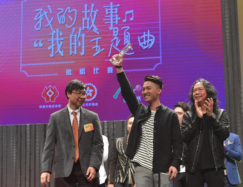 禁毒常务委员会主席张建良医生（左）今日（十二月十六日）在「我的故事　我的主题曲」抗毒歌唱比赛为获得冠军的古立权（中）颁奖。