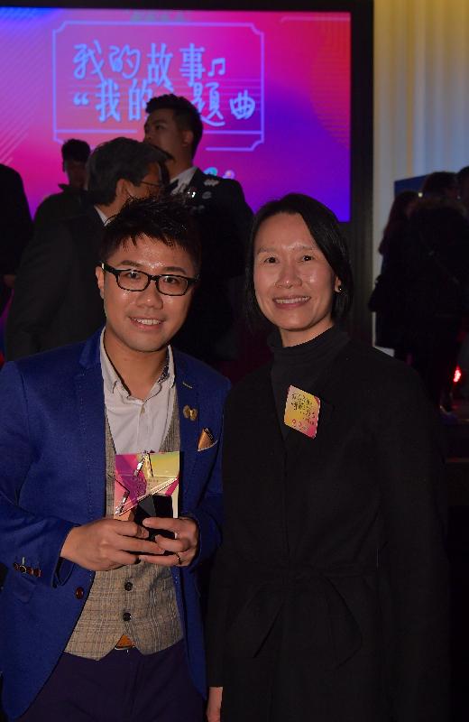 禁毒专员陈咏雯（右）今日（十二月十六日）在「我的故事　我的主题曲」抗毒歌唱比赛祝贺获得网上人气大奖的参赛者何威信（左）。