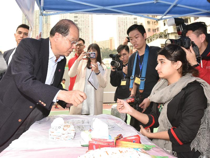 The Chief Secretary for Administration, Mr Matthew Cheung Kin-chung (first left), tours a carnival held by the Hong Kong Community Network today (December 23).