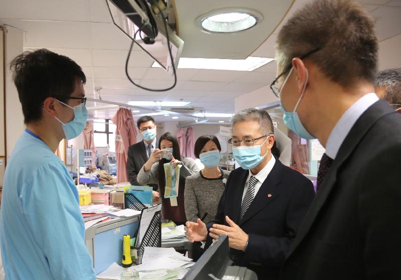 The Hospital Authority Chairman, Professor John Leong (second right), talks to the front-line staff of Kwong Wah Hospital on the service operation of the Accident and Emergency Department this afternoon (December 27).