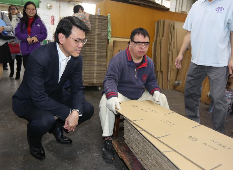 商務及經濟發展局局長邱騰華（左一）今日（一月八日）到訪九龍城區，期間前往香港盲人輔導會盲人工廠參觀，了解殘疾人士學習紙箱製作的情況。